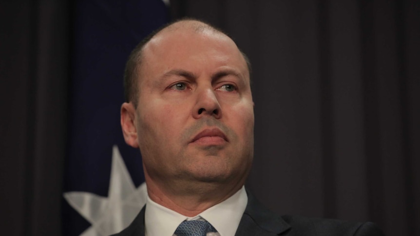 A close up of a straight faced Josh Frydenberg