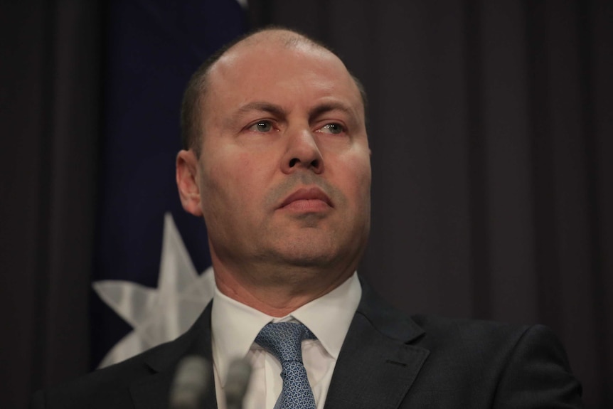 A close up of a straight faced Josh Frydenberg