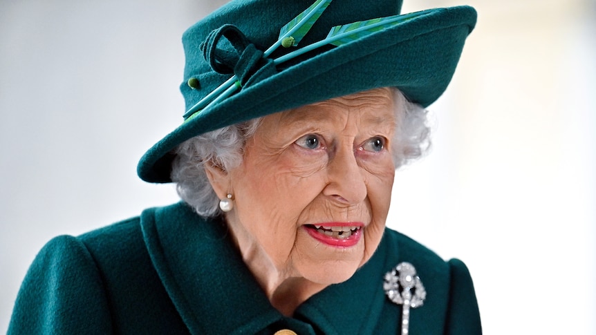 Queen Elizabeth II dressed in a green hat and dress.