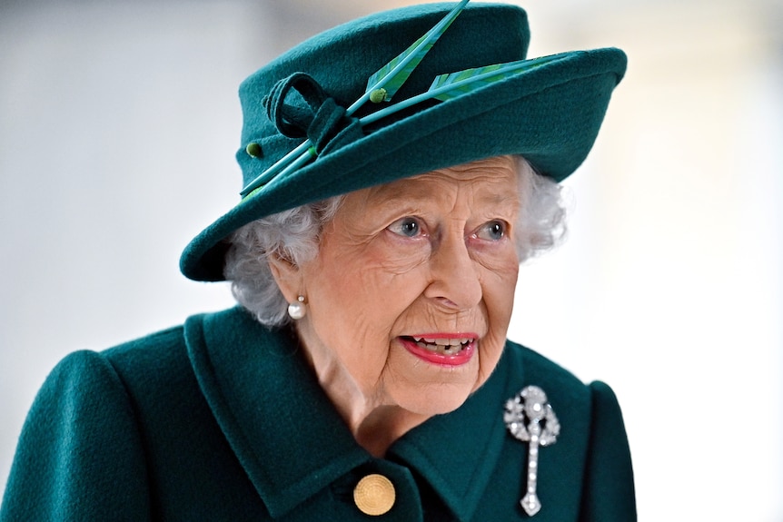 伊丽莎白二世女王戴着绿色帽子和长袍。