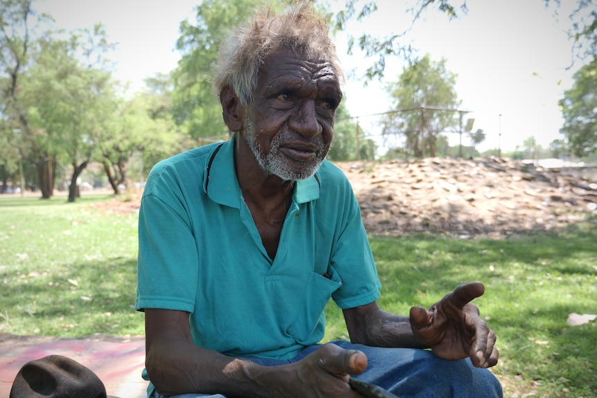 An Indigenous man in a green polo shirt sitting down.