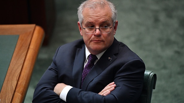 Scott Morrison sits in parliament with his arms crossed