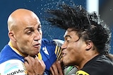 A Parramatta NRL player holds a Penrith opponent around his upper body as he attempts a tackle.