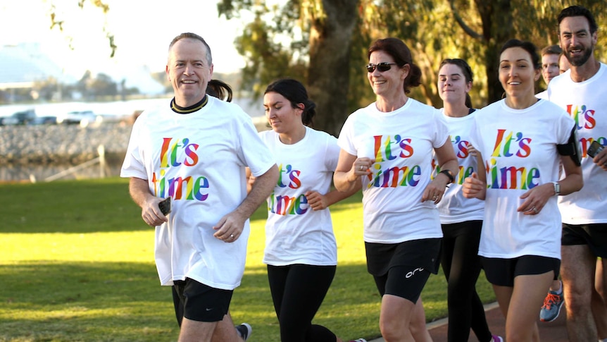 A smiling Bill Shorten leads a pack of joggers wearing "It's Time" t-shirts.