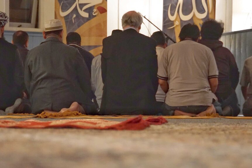 Muslims on a mat in a church praying.