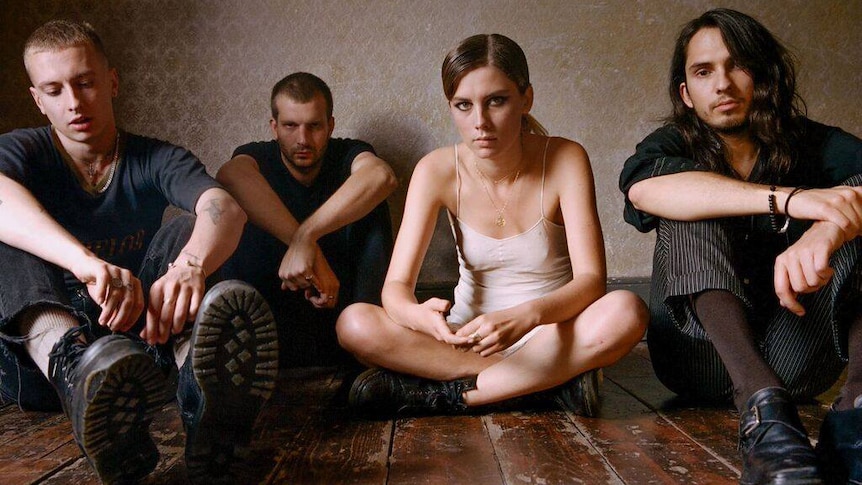 Wolf Alice seated on the ground