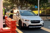Police officers perform checks as car crosses newly reopened Queensland-NSW border bubble 