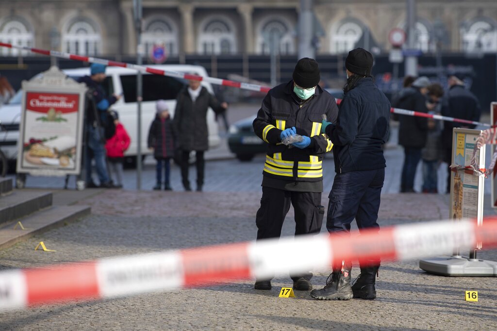 警察站在一个警示水龙头后面e 在德累斯顿的 Schinkelwache 大楼。” class=