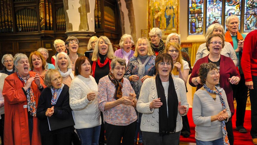 Choir members practising their singing in a church.