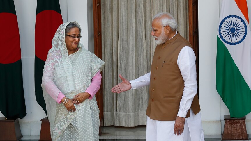 Indian Prime Minister Narendra Modi, right, extends his hand to his Bangladeshi counterpart Sheikh Hasina.