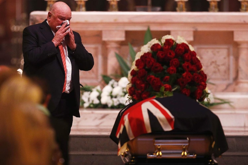 Lindsay Fox walks past Sisto Malaspina's coffin inside St Patrick's Cathedral.