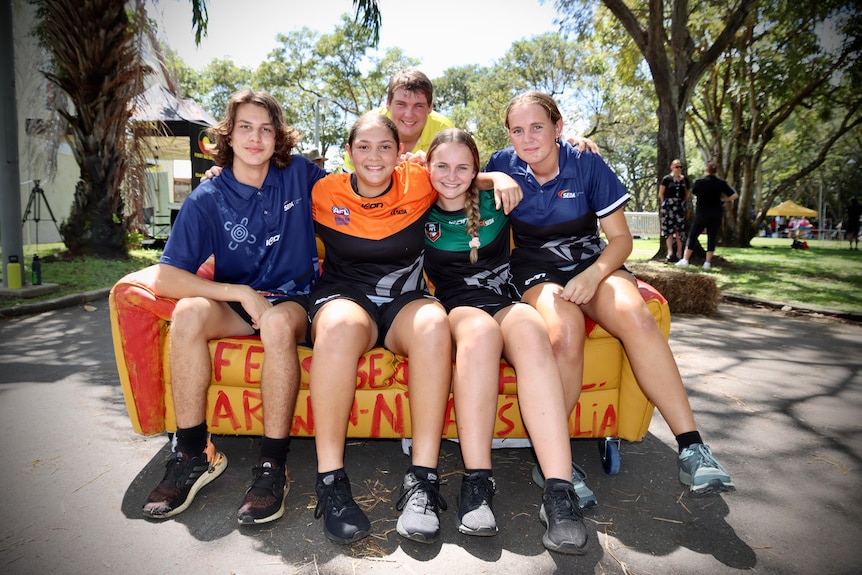 teenagers sitting on an orange couch