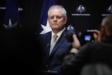 Scott Morrison with out-of-focus media in the foreground.