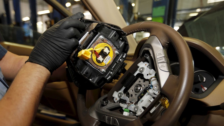 A Takata airbag inflator is removed from a Honda vehicle