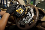 A Takata airbag inflator is removed from a Honda vehicle