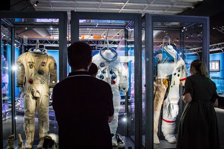 People viewing space suits.