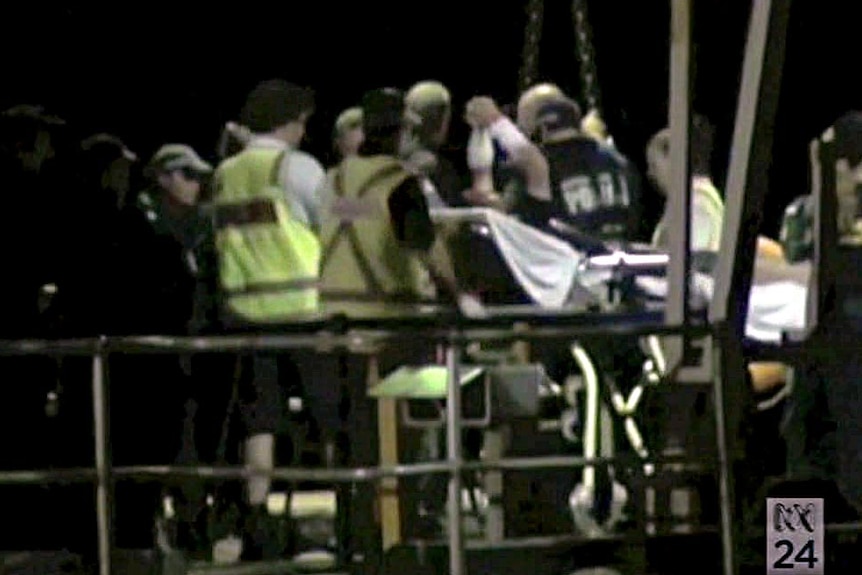 Asylum seekers on stretchers are taken ashore at Christmas Island.