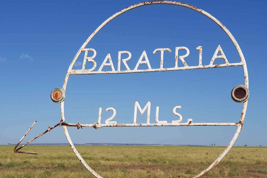 White metal sign saying 12 miles to reach Baratria Station near Longreach in western Queensland.