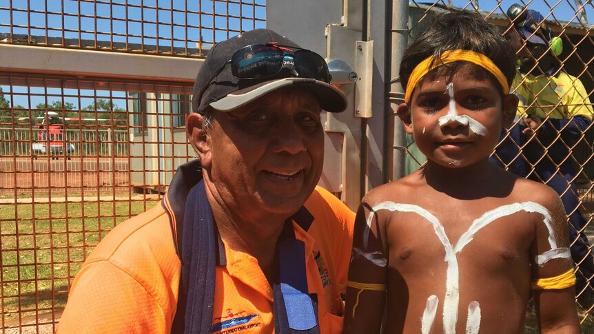 Djarindjin Airport Manager Kimberley Baird with young Indigenous boy outside airport.