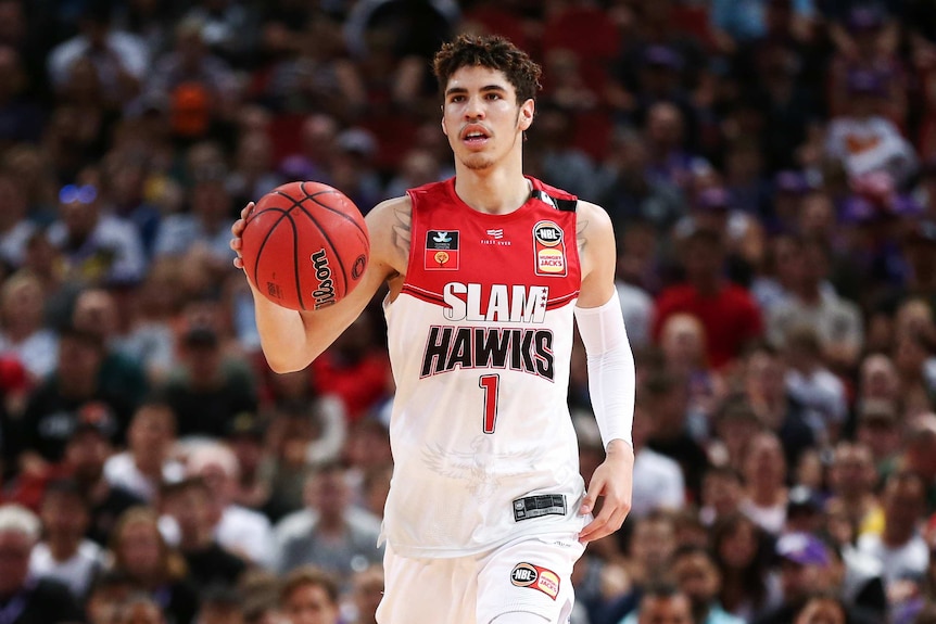 A Illawarra Hawks NBL player dribbles the ball during a game.