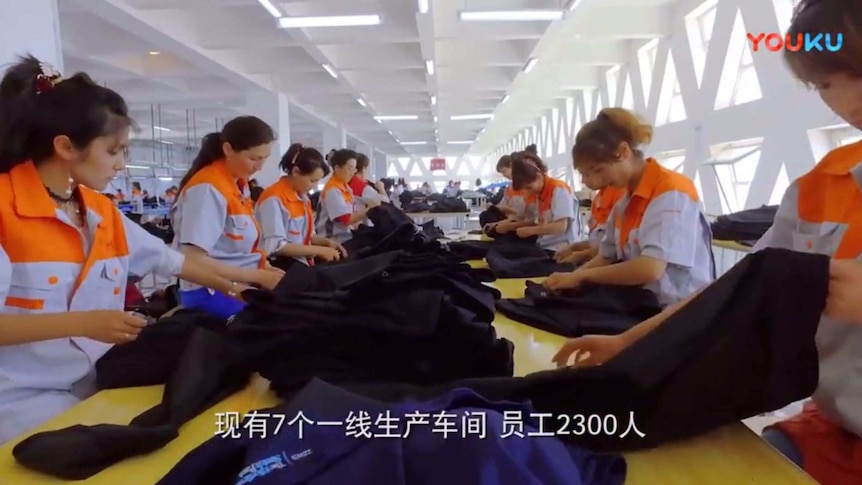 Golden Future employees check pants at a factory in Xinjiang. The label of a pair of Croft & Barrow pants is visible.