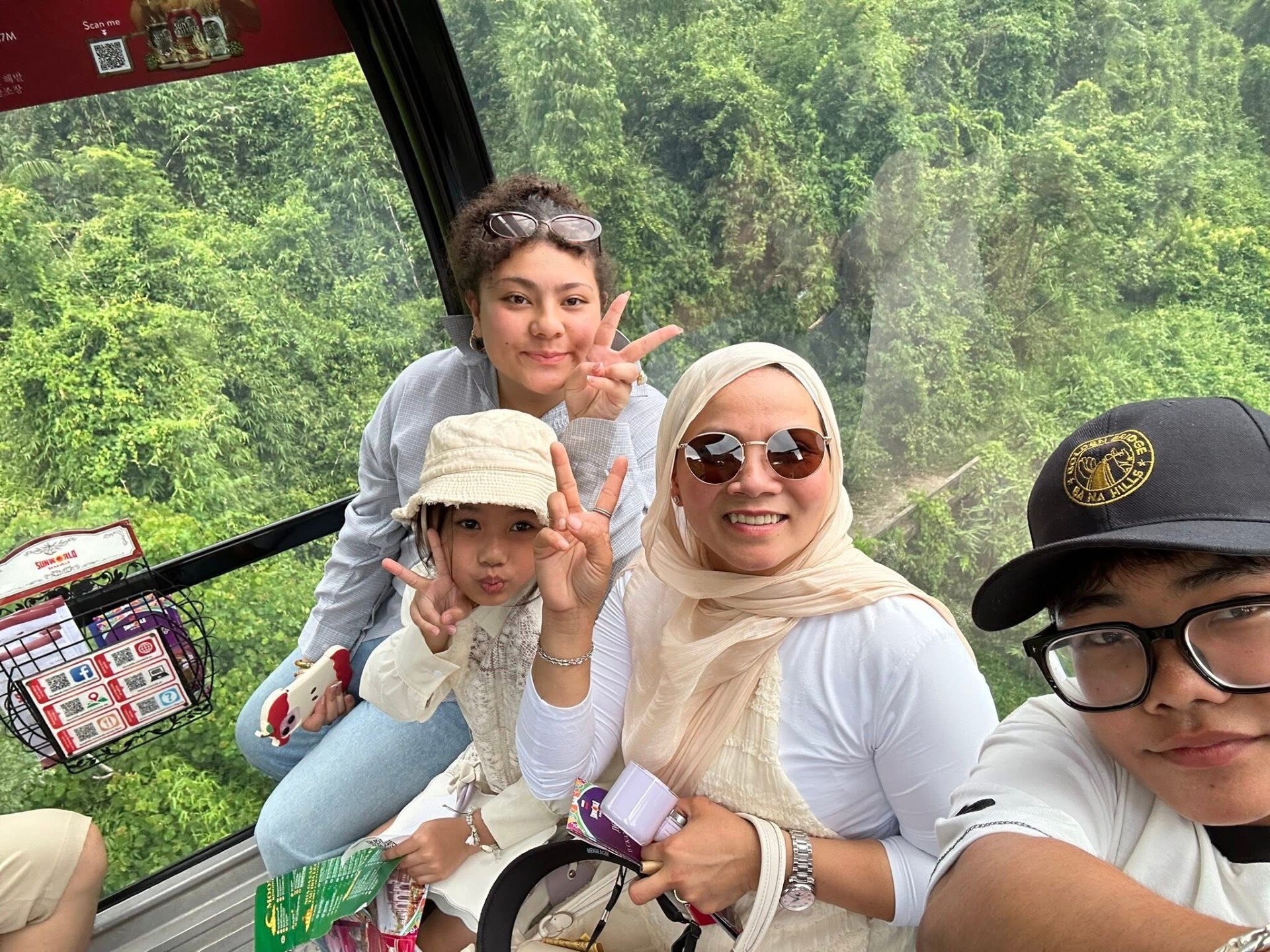 Family on a train with bush behind.