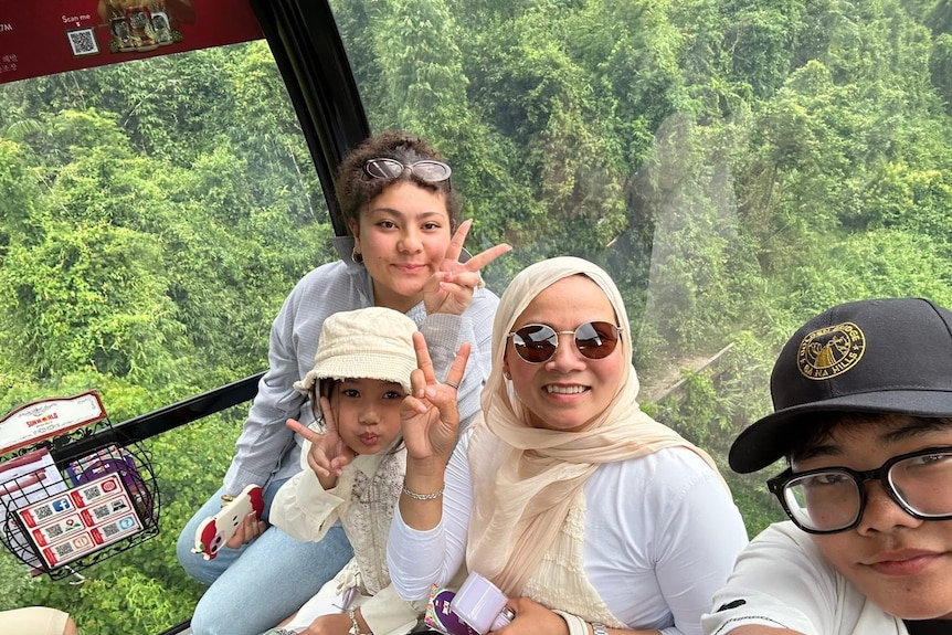Family on a train with bush behind.
