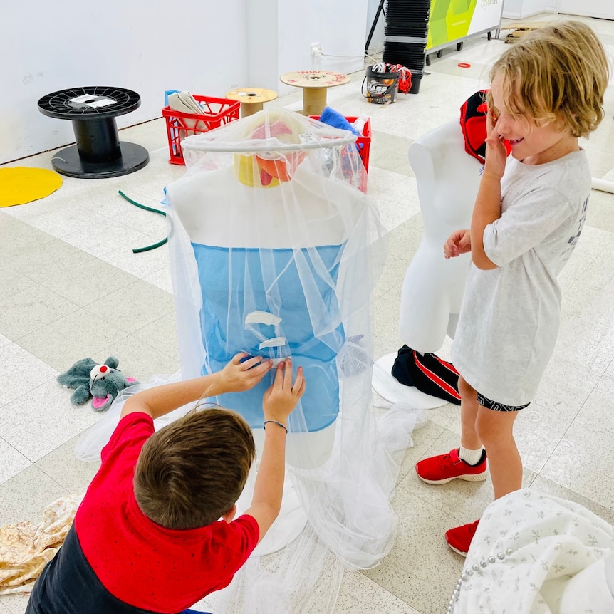 Two children playing with fabric