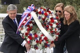 NASA officials and relatives of victims hold a wreath at a ceremony commemorating the anniversary of the Columbia tragedy