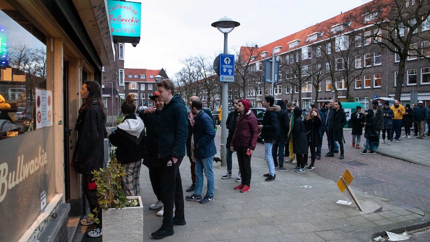 People queue to buy marijuana at coffeeshop Bulwackie in Amsterdam.