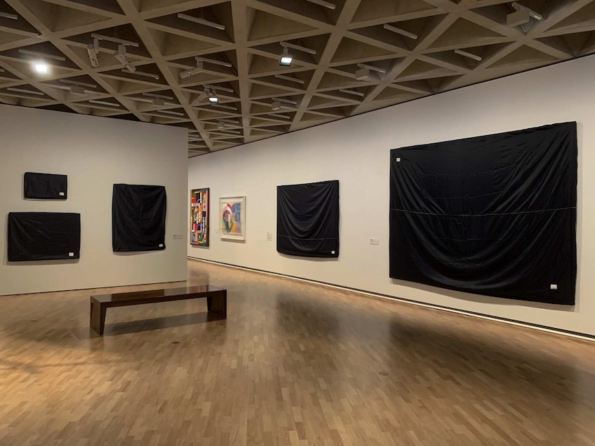Several paintings hanging at the national gallery are covered in black sheets