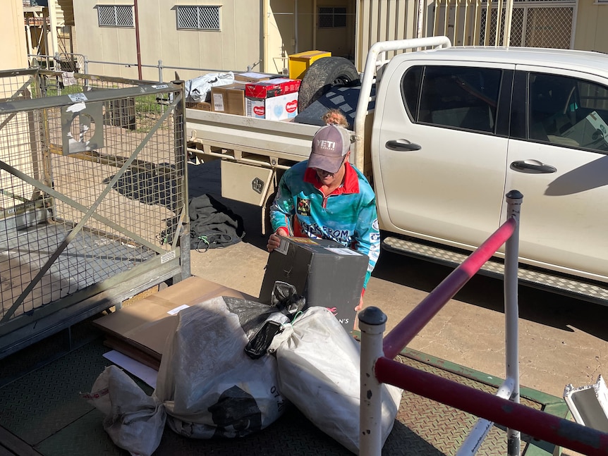 Woman loads mail onto car trailer