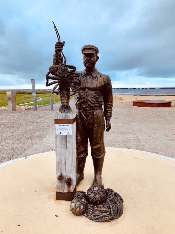 A statue of a fisherman holding a crayfish in Port MacDonnell.