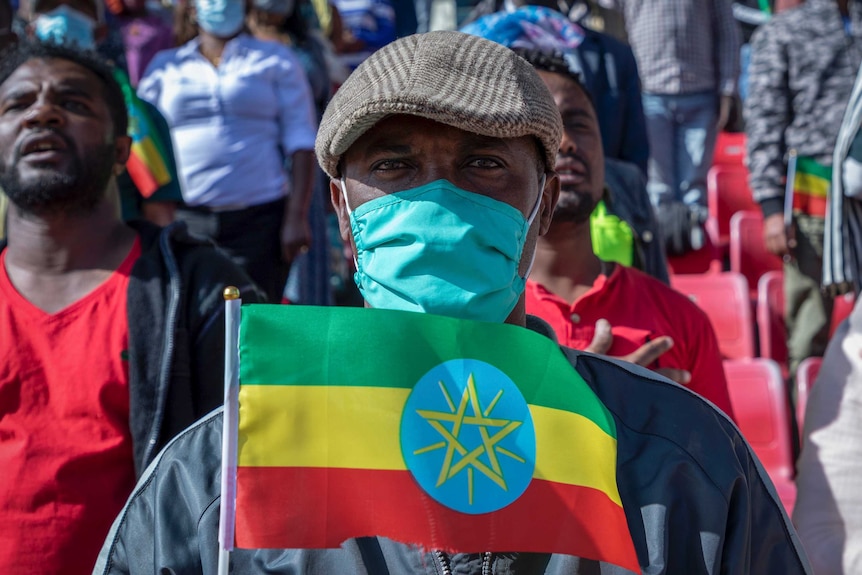A man holds an Ethiopian national flag as he waits to give blood