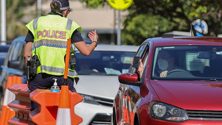 Police check a motorist at the Queensland road border.