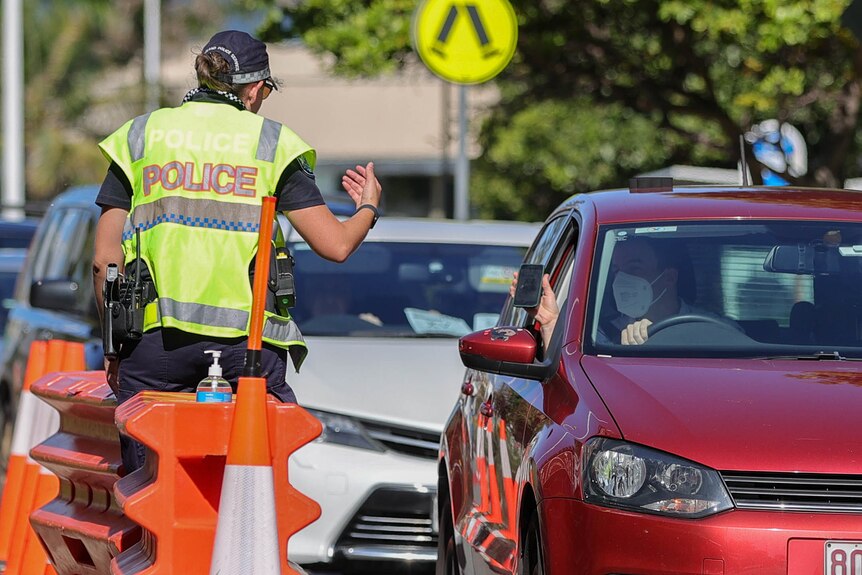 Police check a motorist at the Queensland road border.