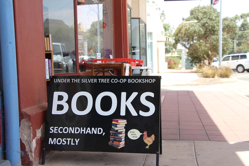 The outside of a book co-op with a sign out the front.