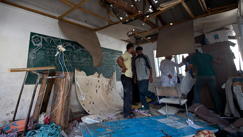 Palestinian men inspect the damage at a UN school at the Jabalia refugee camp.