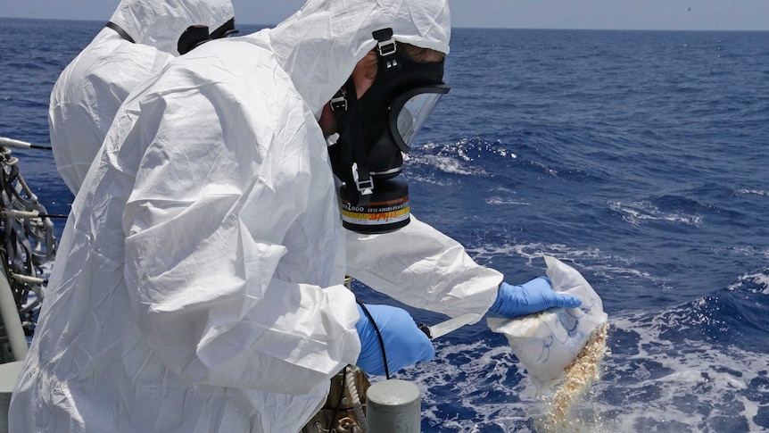 Crew members destroy the drugs found on the suspected drug smuggling vessel.