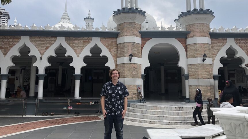 Man standing in front of a mosque