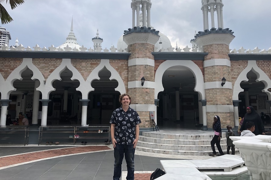 Man standing in front of a mosque