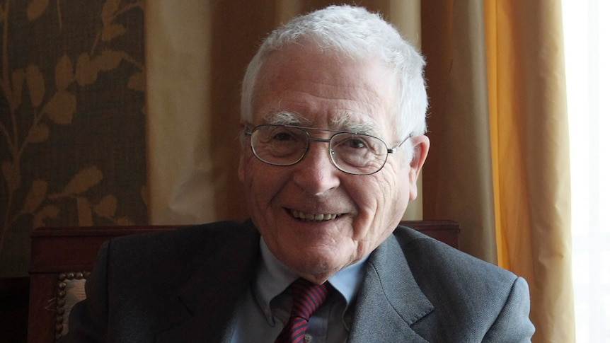 James Lovelock smiles at the camera while wearing a suit and tie.