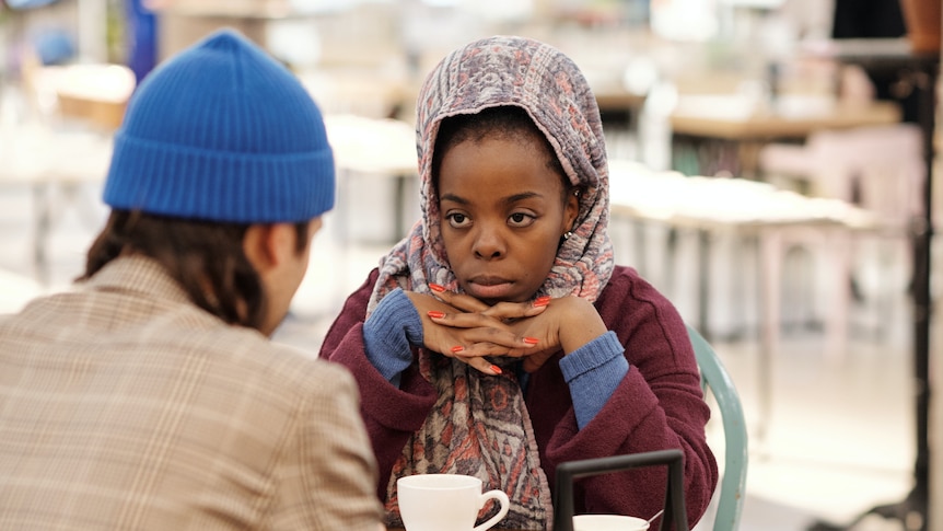 Woman looking unhappy while having coffee with a man, in a story about how to cope when your partner changes.