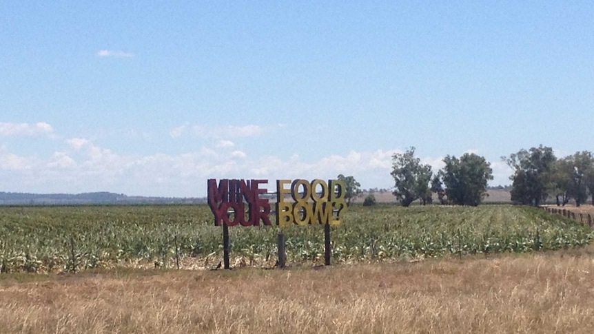 A sign saying 'Mine your food bowl?' stands in a paddock on the Liverpool Plains