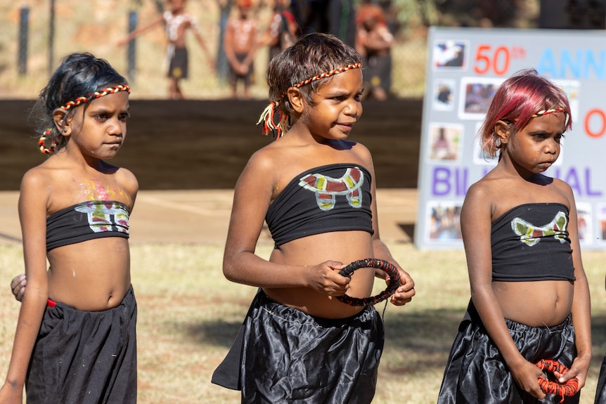 Three Aboriginal girls wear traditional costumes
