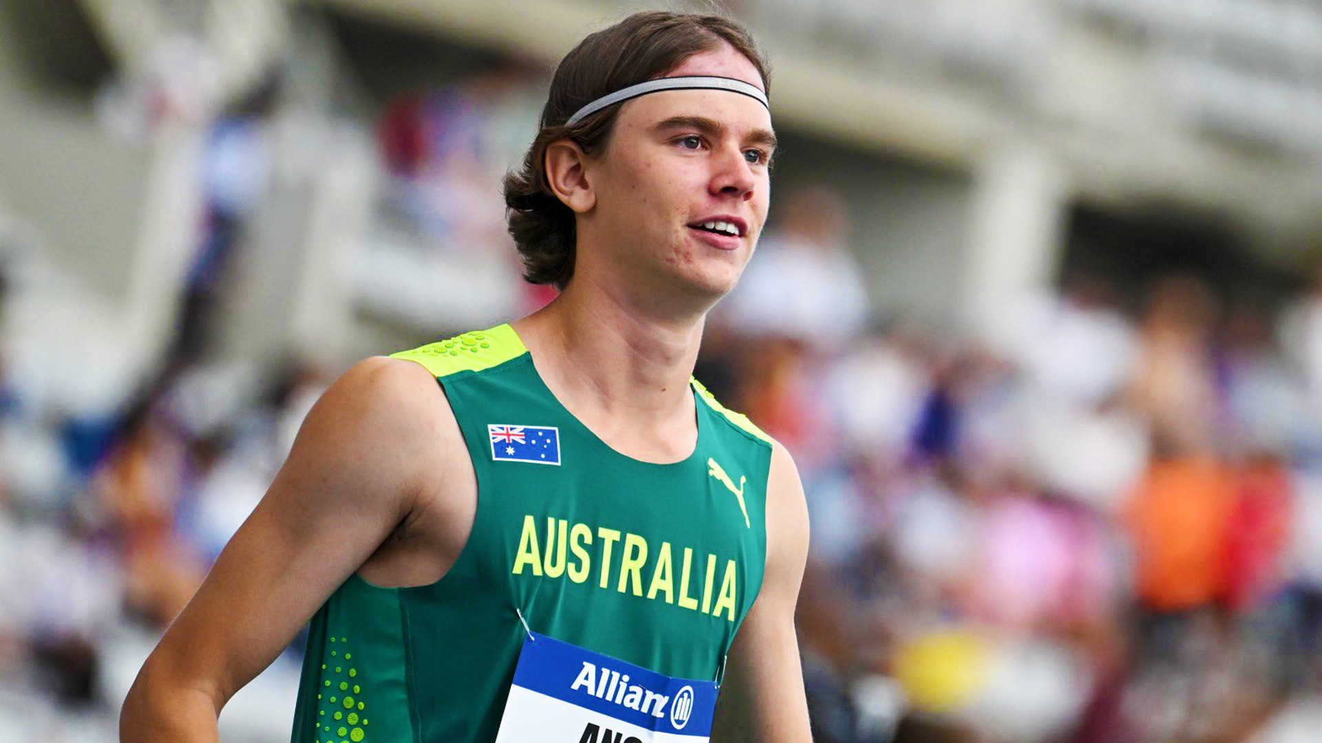 Angus on the running track before his race wearing Australia uniform and headband.