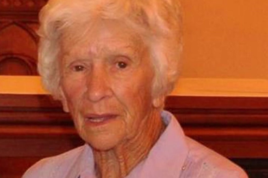An elderly woman with short grey hair looking at the camera.