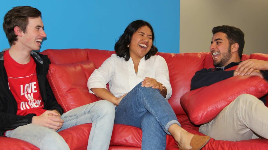 Three people laughing on a lounge