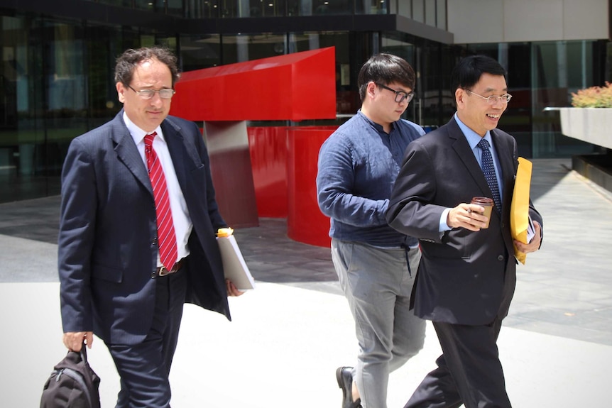 Three men walk outside an ACT court.