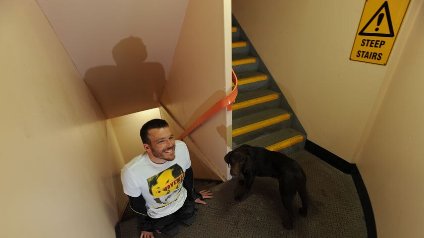 Australian paralympian Kurt Fearnley with his dog Alby after crawling up Sydney Tower